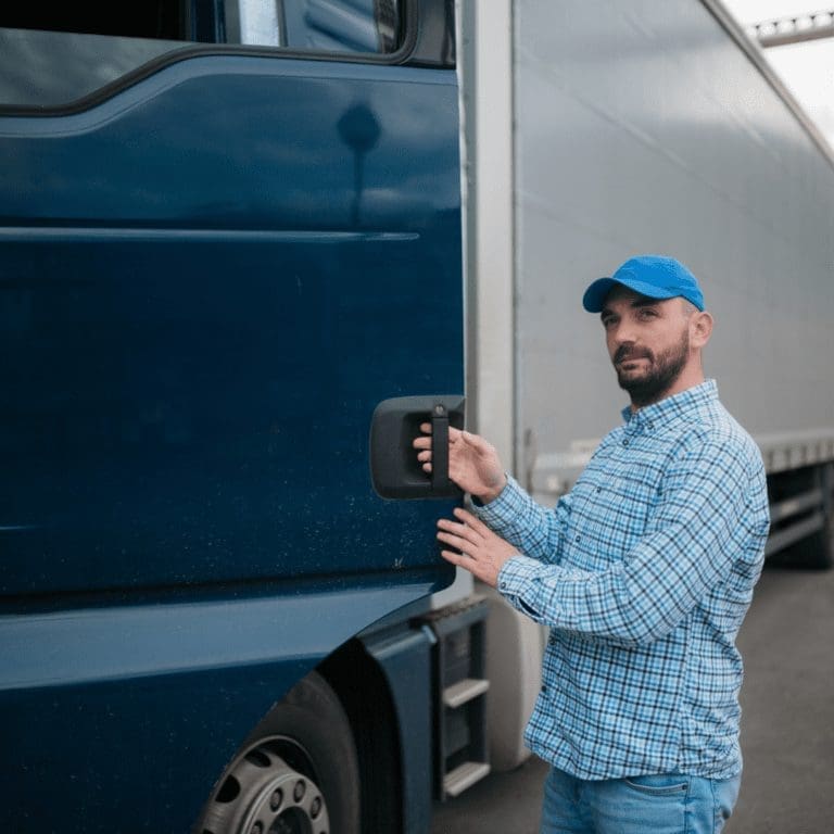 En la imagen se muestra un conductor masculino abriendo la puerta de un camión