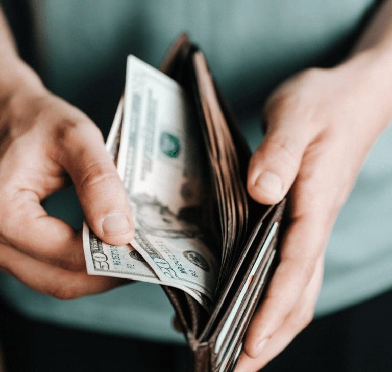En la imagen se muestra un hombre sacando dinero de una cartera