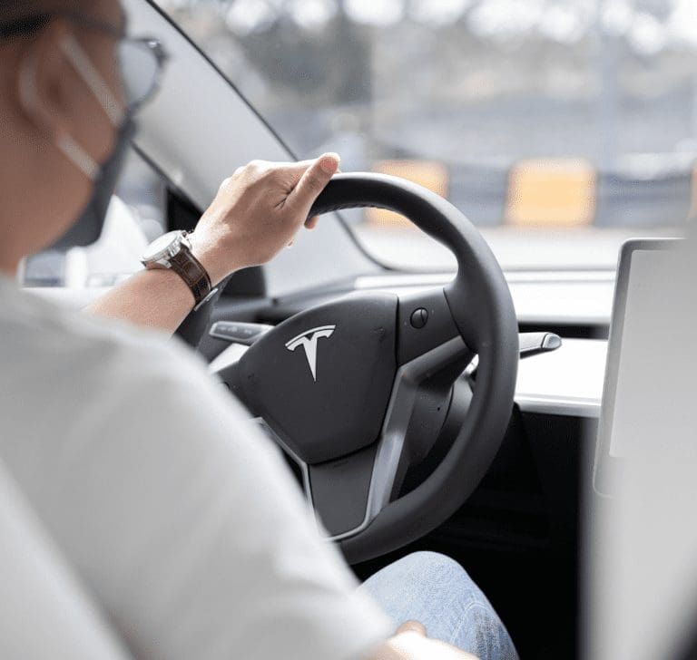 En la imagen se muestra una persona conduciendo un Tesla