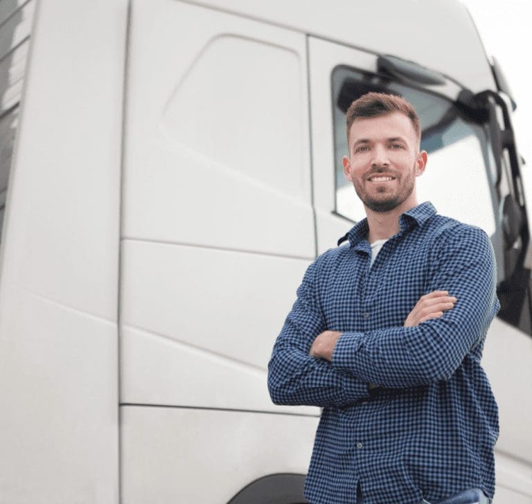 En la imagen se muestra un camionero frente a un camión